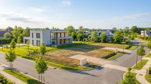 Vue aérienne d'un lotissement moderne à Olivet avec une maison contemporaine et des terrains constructibles.